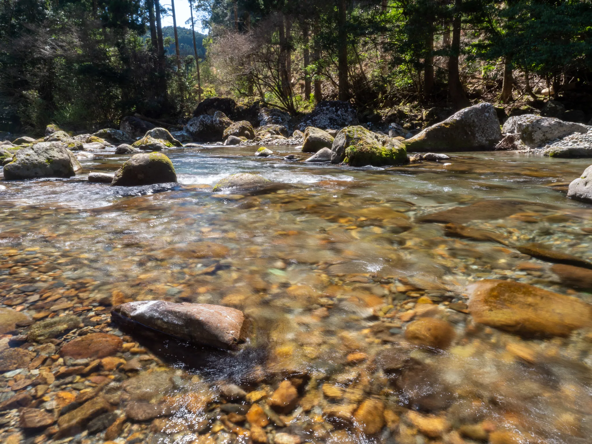 Clear river water running over amber pebbles